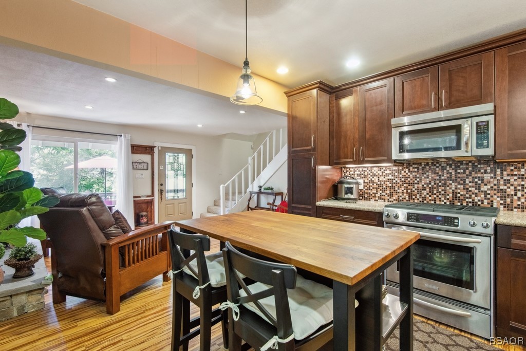 23697 Bowl Road Crestline, CA 92325 - Photo 14 of 28 a kitchen with a stove a sink a microwave a dining table and chairs
