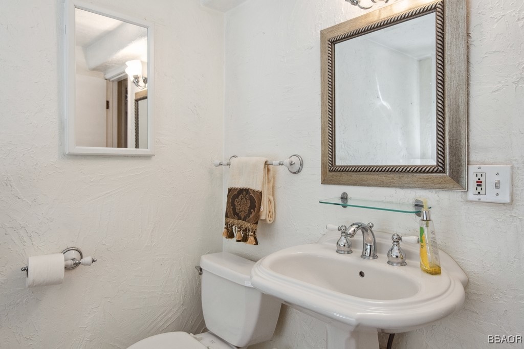 23697 Bowl Road Crestline, CA 92325 - Photo 26 of 28 a bathroom with a toilet sink and mirror