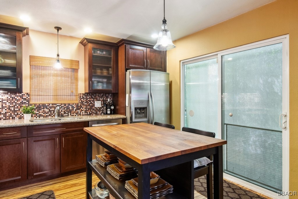 23697 Bowl Road Crestline, CA 92325 - Photo 10 of 28 a kitchen with stainless steel appliances granite countertop a table chairs refrigerator and sink