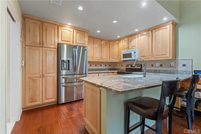 a kitchen with stainless steel appliances granite countertop a stove refrigerator sink and cabinets