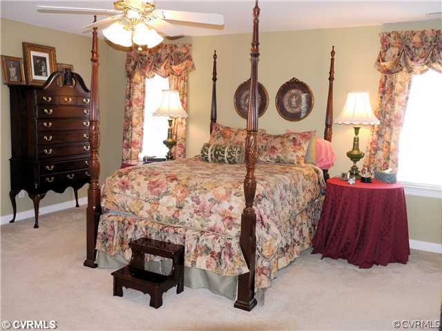 1207 Goswick Ridge Road Midlothian, VA 23114 - Photo 9 of 12 a bedroom with a bed and a chandelier