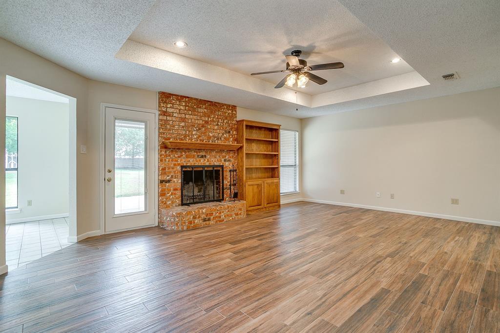 8613 Silver Creek Road White Settlement, TX 76108 - Photo 6 of 40 an empty room with wooden floor fireplace and windows