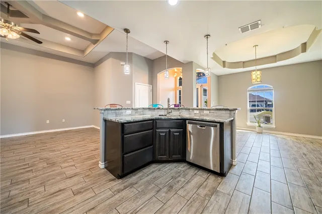 a kitchen with stainless steel appliances granite countertop a sink and a stove