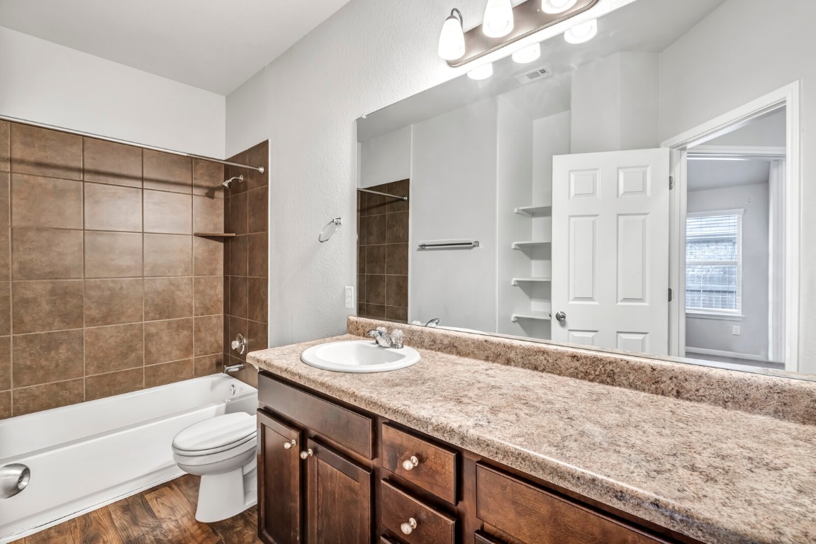 539 Merlin Lane Leander, TX 78641 - Photo 13 of 18 Full bath featuring vanity, shower / bathtub combination, and dark wood-style floors