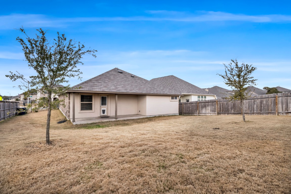 539 Merlin Lane Leander, TX 78641 - Photo 18 of 18 Back of property featuring a fenced backyard, a patio, and a shingled roof