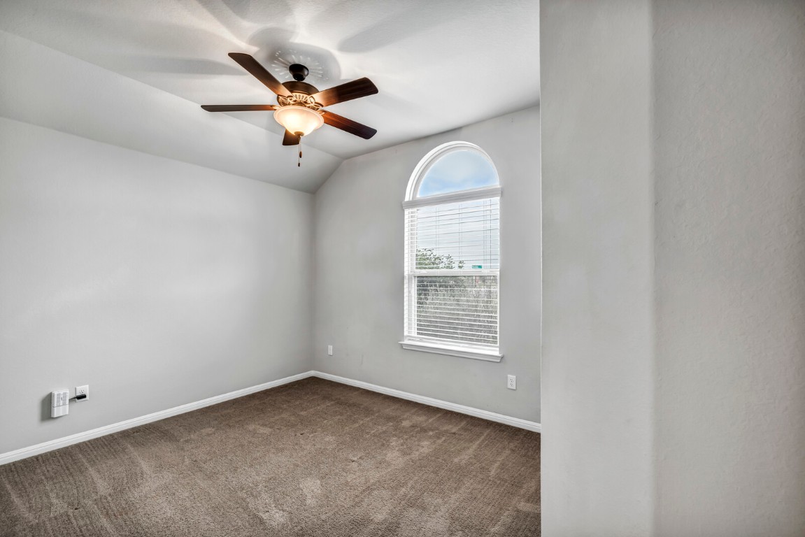539 Merlin Lane Leander, TX 78641 - Photo 3 of 18 Empty room with carpet flooring, vaulted ceiling, and a ceiling fan