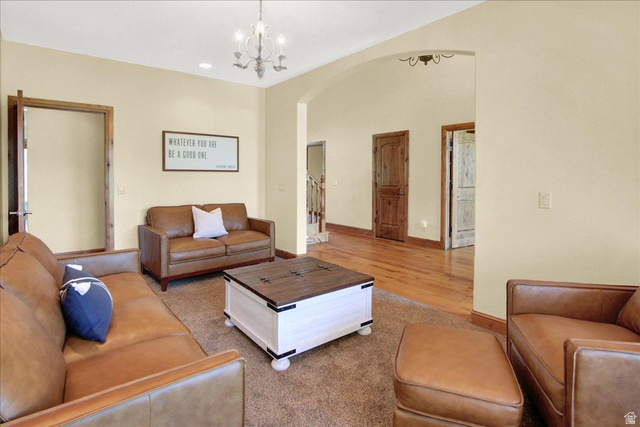 667 Hardscrabble Road Morgan, UT 84050 - Photo 13 of 51 Living room with arched walkways, light carpet, and hanging lights