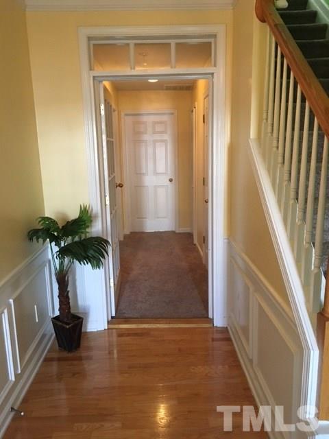 7010 Mead Lane Raleigh, NC 27613 - Photo 2 of 22 a view of a hallway with wooden floor and a living room