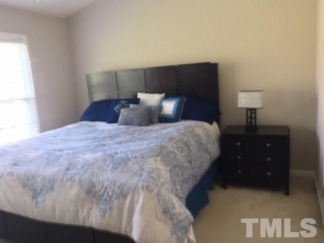 7010 Mead Lane Raleigh, NC 27613 - Photo 15 of 22 a large bed sitting in a bedroom next to a window