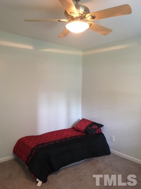 7010 Mead Lane Raleigh, NC 27613 - Photo 4 of 22 a bedroom with a bed and a chandelier fan