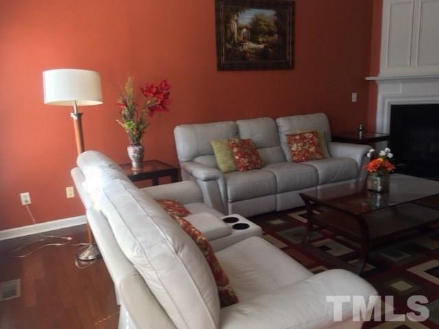 7010 Mead Lane Raleigh, NC 27613 - Photo 7 of 22 a living room with furniture a lamp and a potted plant