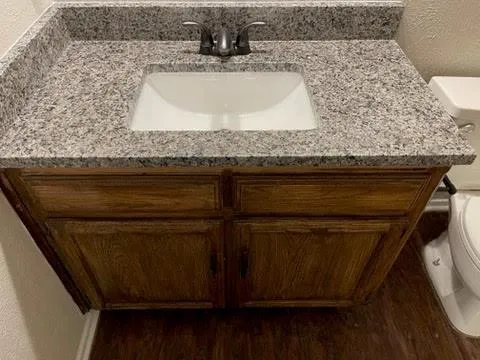 a bathroom with a granite countertop sink and a mirror