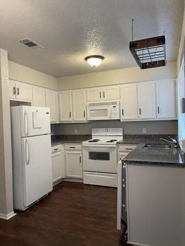 a kitchen with a stove a sink and a refrigerator