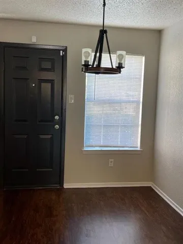 an empty room with wooden floor and cabinet