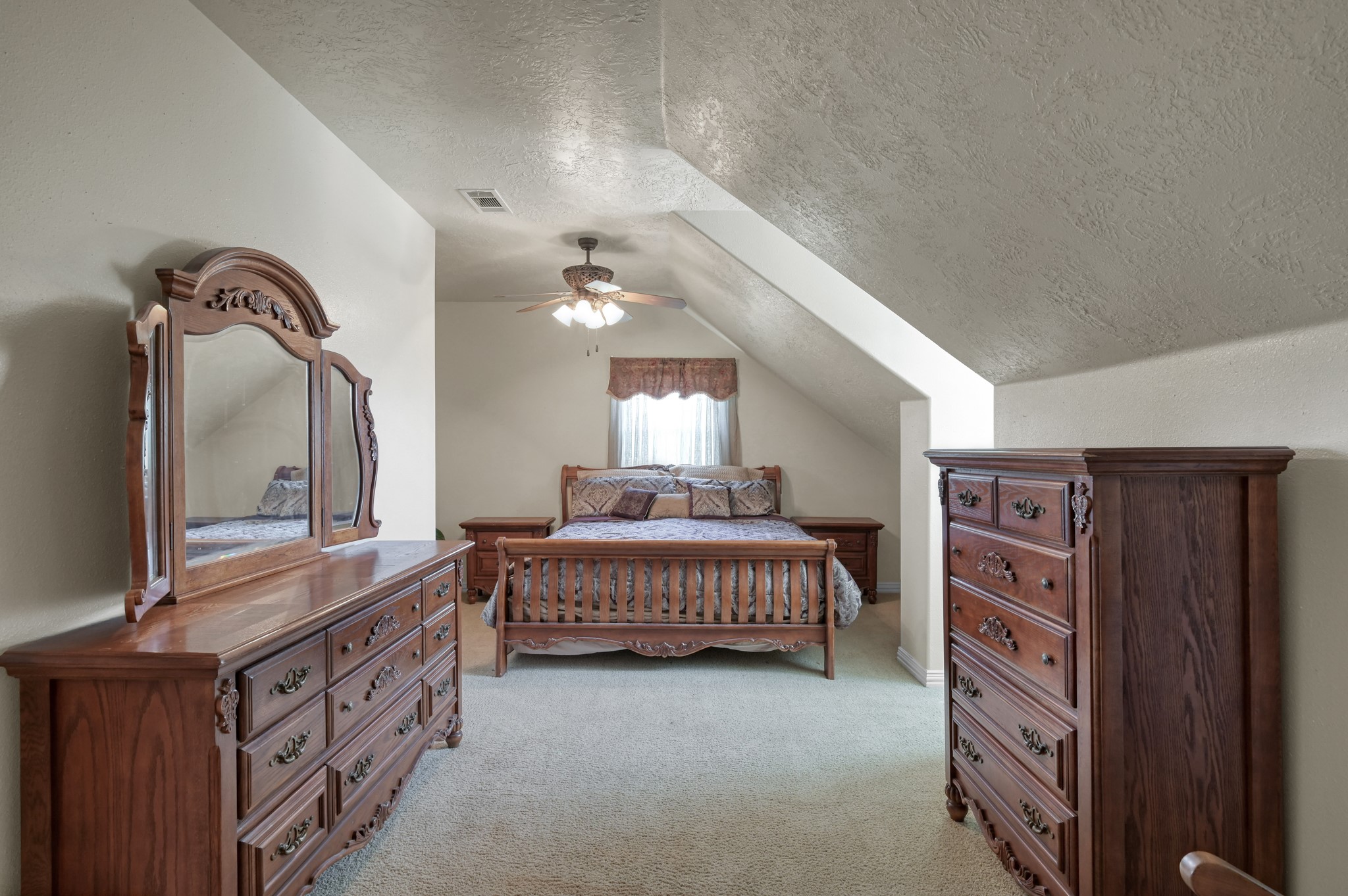 144 Wood Farm Road Huntsville, TX 77320 - Photo 22 of 35 a spacious bedroom with a bed a dresser and potted plants