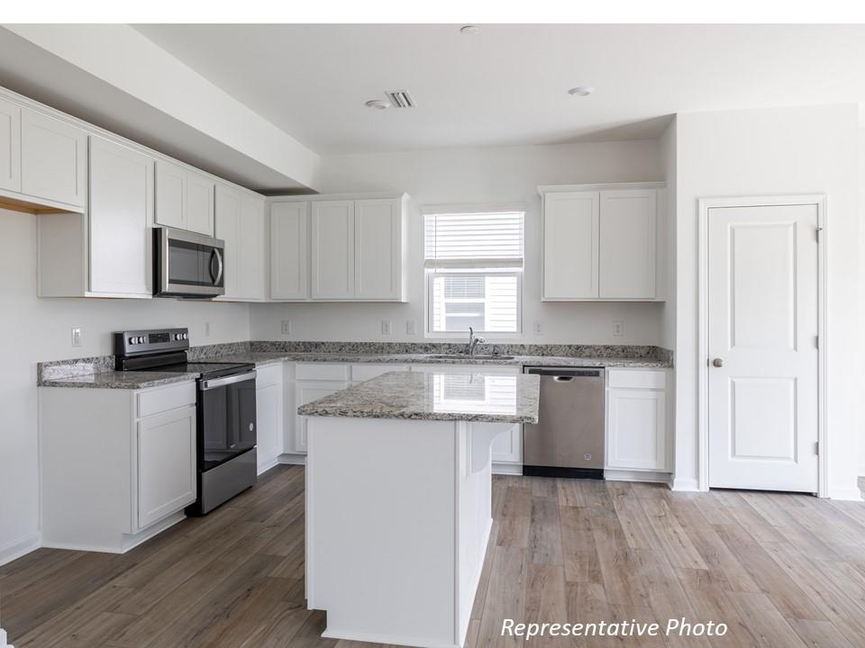 1248 Maple Shade Road Southwest, Unit 74 Concord, NC 28027 - Photo 2 of 11 a kitchen with granite countertop white cabinets and white appliances