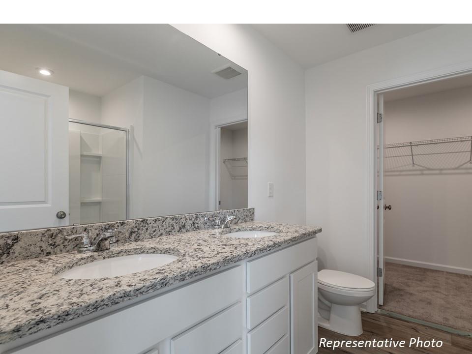 1248 Maple Shade Road Southwest, Unit 74 Concord, NC 28027 - Photo 5 of 11 a bathroom with a granite countertop sink toilet and a mirror