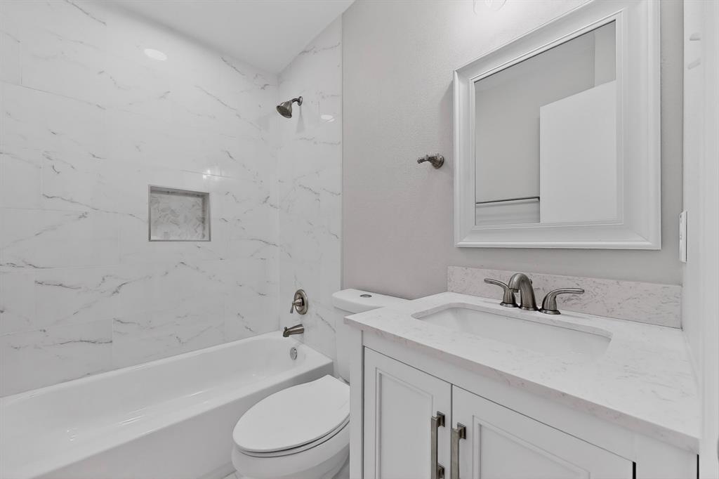 7729 Misty Ridge Drive North Fort Worth, TX 76137 - Photo 10 of 30 a bathroom with a sink toilet a bathtub and a shower