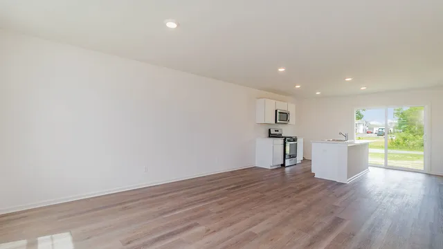 a view of a kitchen with a sink and wooden floor