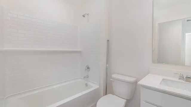 a bathroom with a granite countertop toilet and a sink