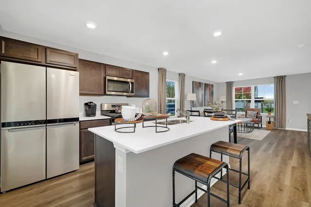 a kitchen with refrigerator and chairs