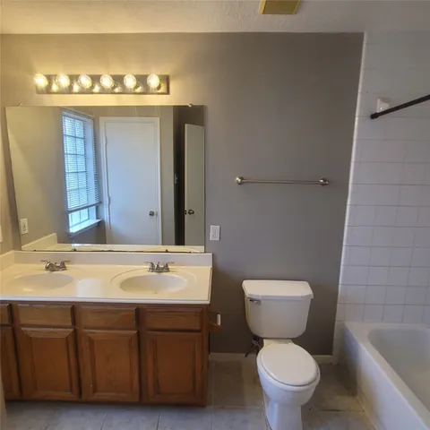 a view of an empty room with chandelier and fireplace