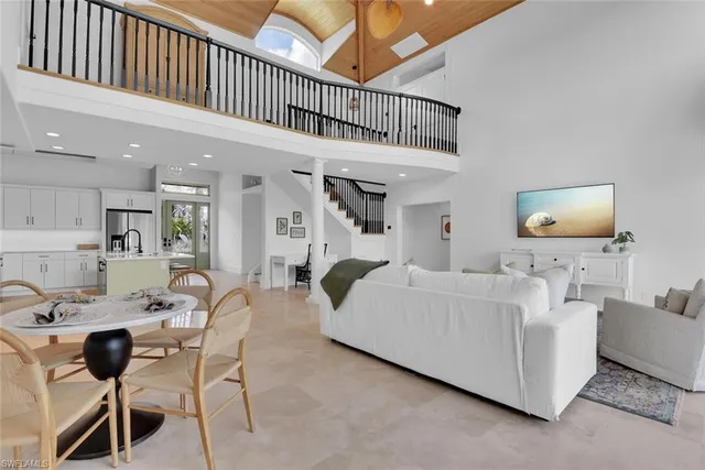 a living room with furniture a flat screen tv and a chandelier