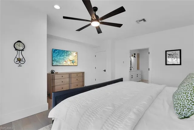 a bedroom with a large bed and a chandelier