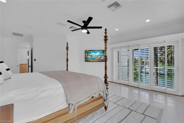 a bedroom with a balcony a bed and a window