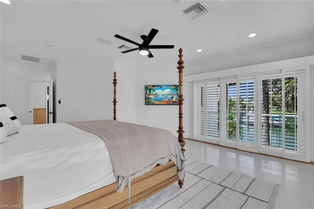 a bedroom with a balcony a bed and a window