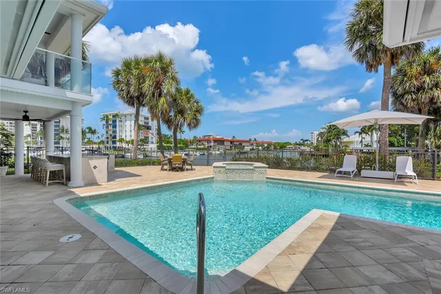 a view of a swimming pool with a table and chairs under an umbrella