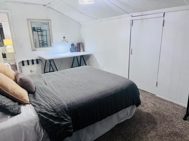a bedroom with a bed a table and chair