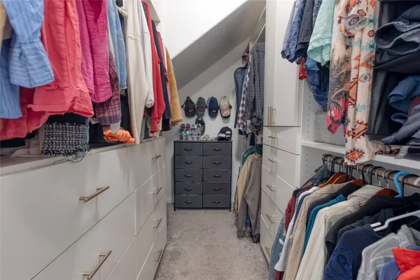 a view of walk in closet with clothes