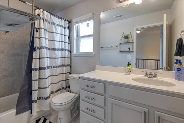 a bathroom with a sink toilet vanity and shower
