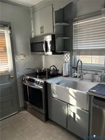 a kitchen with stainless steel appliances a sink stove and cabinets