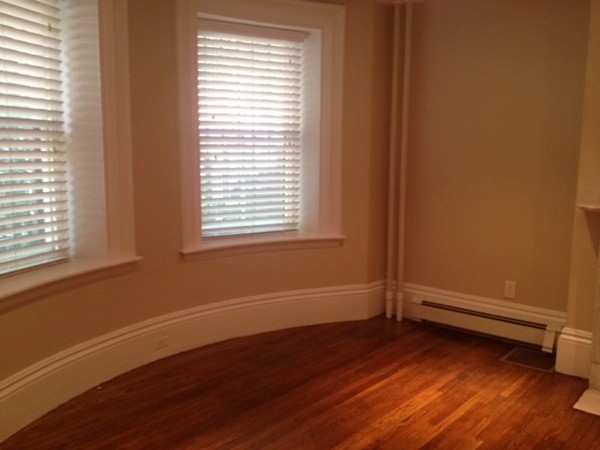 a view of a room with wooden floor and a window