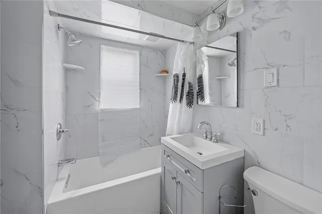 a bathroom with a bathtub shower sink vanity and toilet
