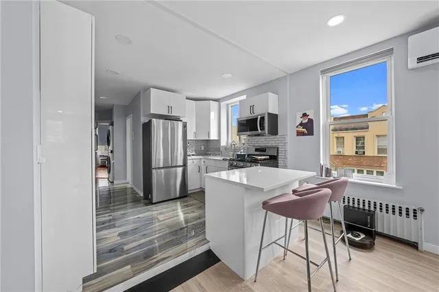 a kitchen with kitchen island a refrigerator stove microwave and cabinets