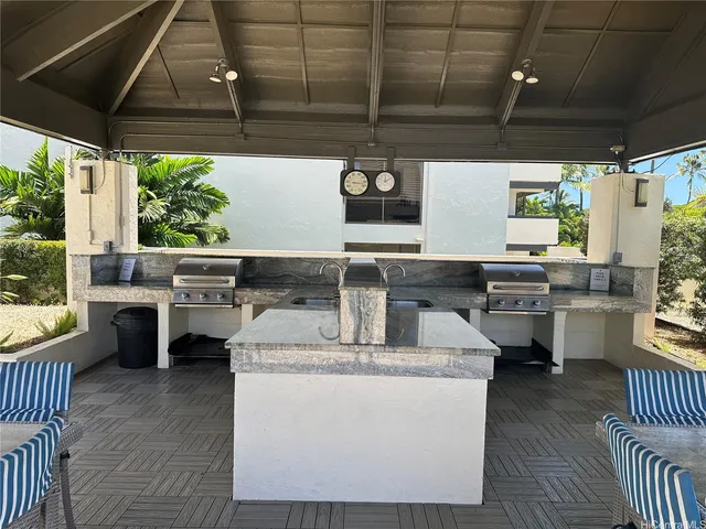 a kitchen with stainless steel appliances granite countertop a sink a stove and a wooden floors
