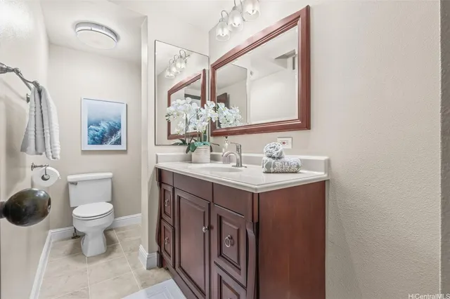 a bathroom with a sink vanity granite and toilet