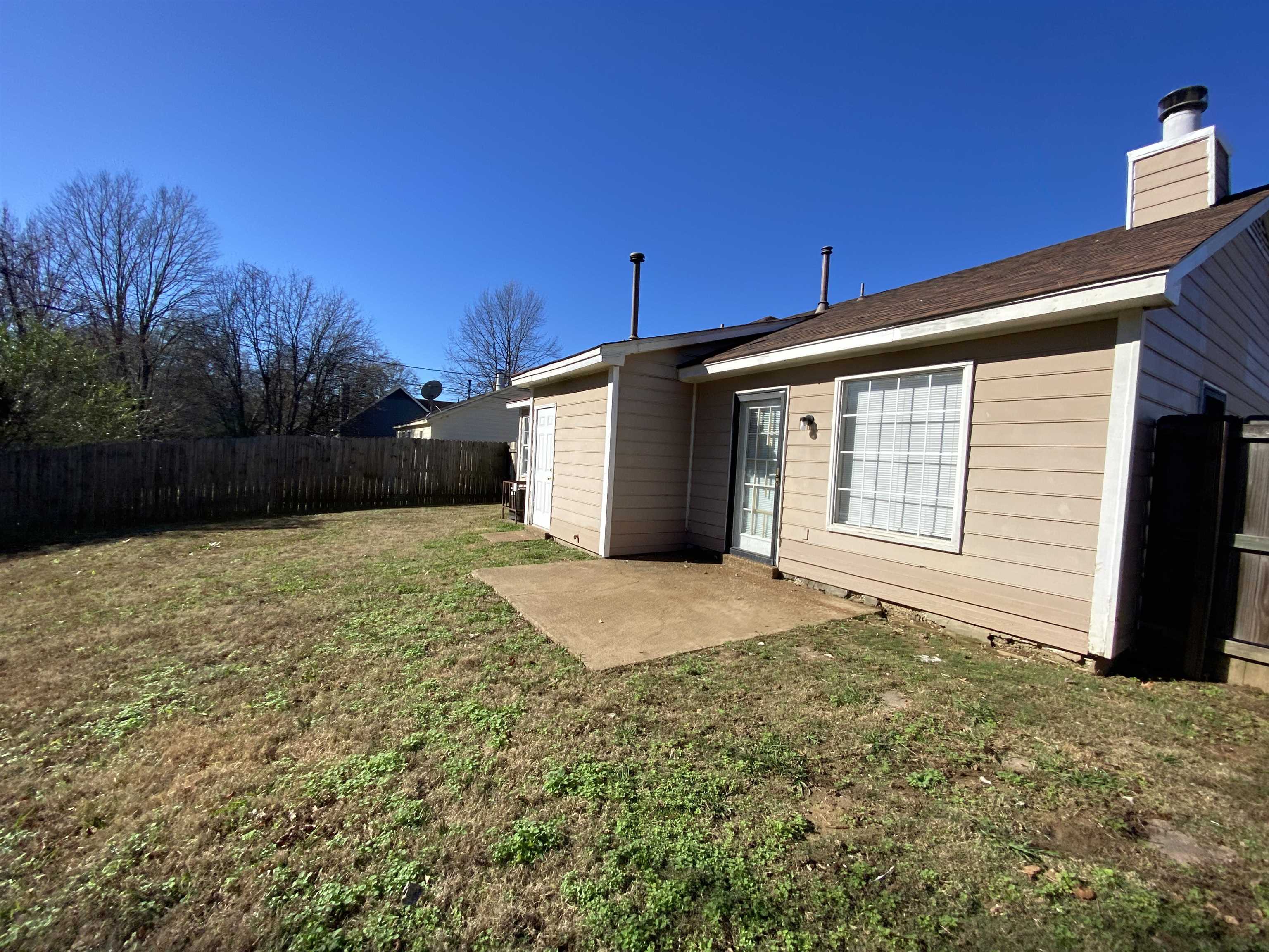 5950 Chadwell Road Millington, TN 38053 - Photo 14 of 14 Back of house featuring a patio, a fenced backyard, and a chimney