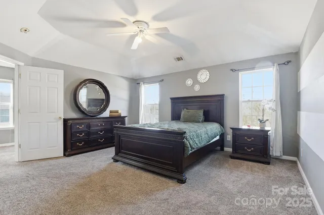 a spacious bedroom with a bed and a ceiling fan