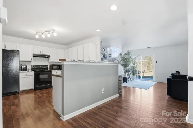 a kitchen with a sink stainless steel appliances and white cabinets