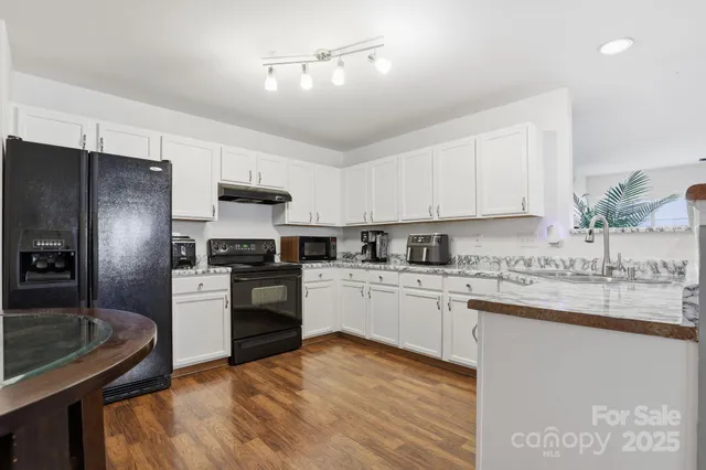 a kitchen with a sink cabinets and wooden floor