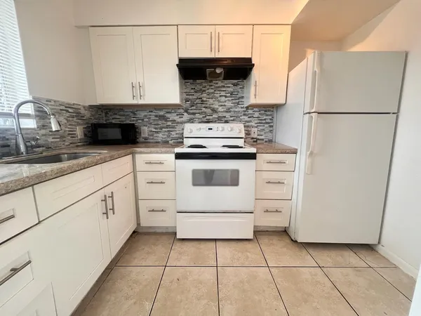 a kitchen with appliances a sink and cabinets