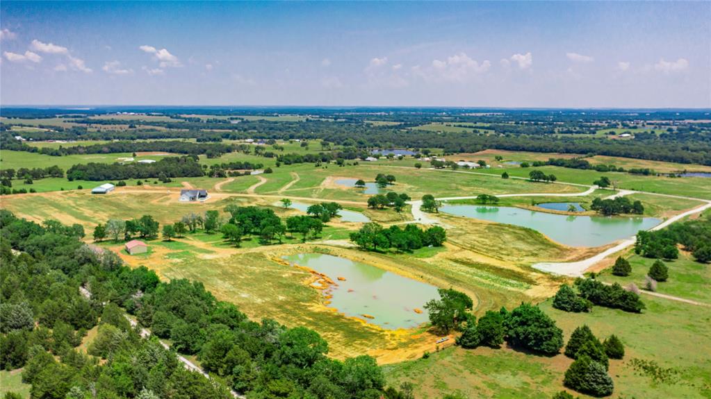 1789 Brumelow Road Whitesboro, TX 76273 - Photo 6 of 30 Expansive rural landscape featuring multiple ponds, scattered trees, and a distant residential structure