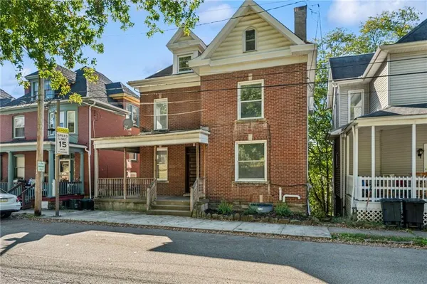 front view of a brick house with a yard