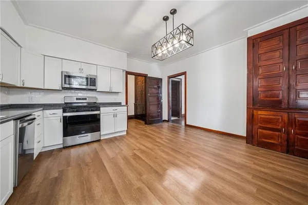 a kitchen with granite countertop a stove top oven and cabinets