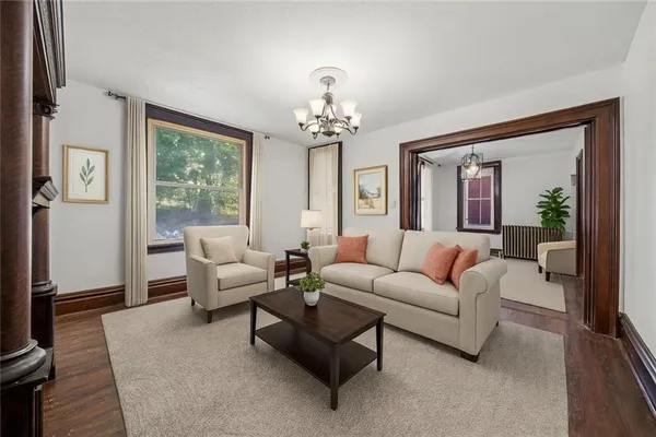 a living room with furniture a chandelier and a large window