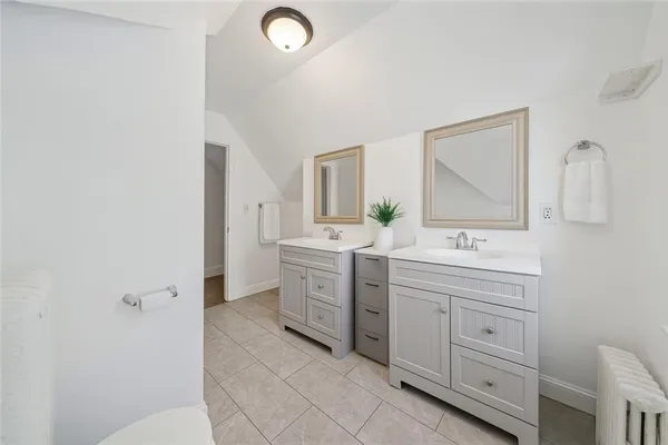 a bathroom with a double vanity sink a toilet and mirror